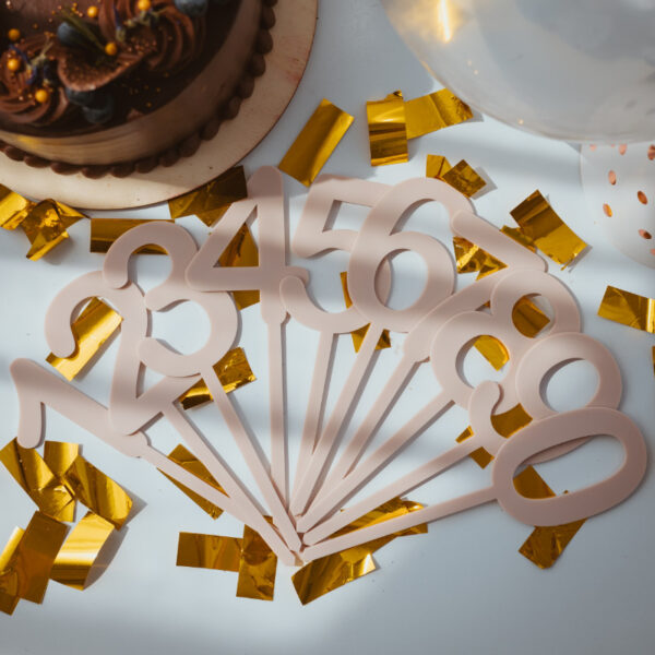 Stofftiger Caketopper Zahlenset einfärbig, alle Zahlen von 0 bis 9 aufgefächert auf goldenem Konfetti