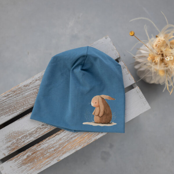 Stofftiger Haube rauchblau Hase, rauchblaue Jerseyhaube mit sitzendem Hasen als Motiv