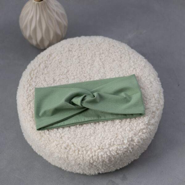 Stofftiger Knoten-Stirnband Mint, mintgrünes Stirnband mit Knoten auf einem Kissen
