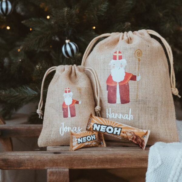 Zwei personalisierte Nikolausäcke mit den Namen Jonas und Hannah vor einem Christbaum