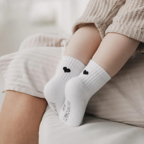 Weiche weiße Eulenschnitt Baby-Socken mit schwarzem Herz auf der Rückseite, aus nachhaltiger Bio-Baumwolle – perfektes Geschenk für kleine Anlässe