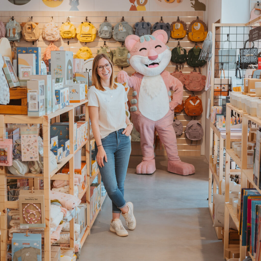 Mitarbeiterin steht im Stofftiger Shop in Großweikersdorf neben einem großen Kuscheltier