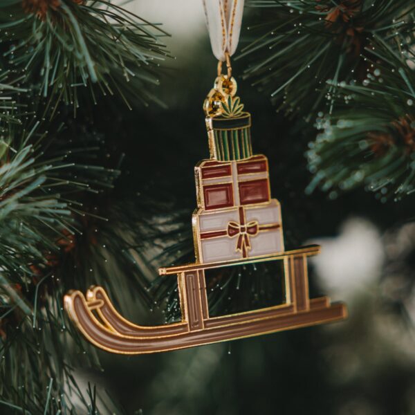 Eulenschnitt Baumschmuck Schlitten, am Christbaum hängend, goldener Schlitten mit Geschenkestapel