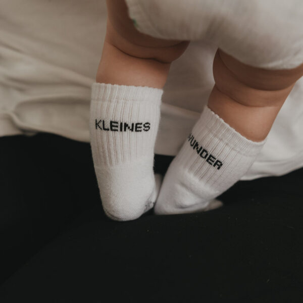 Eulenschnitt Babysocken Kleines Wunder, an Babyfüßen getragen, Schriftzug Kleines und Wunder